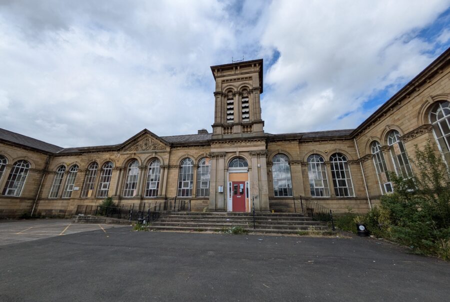 View of Queens Road Neighbourhood Centre in its current dilapidated state, with vegetation growing on its steps.