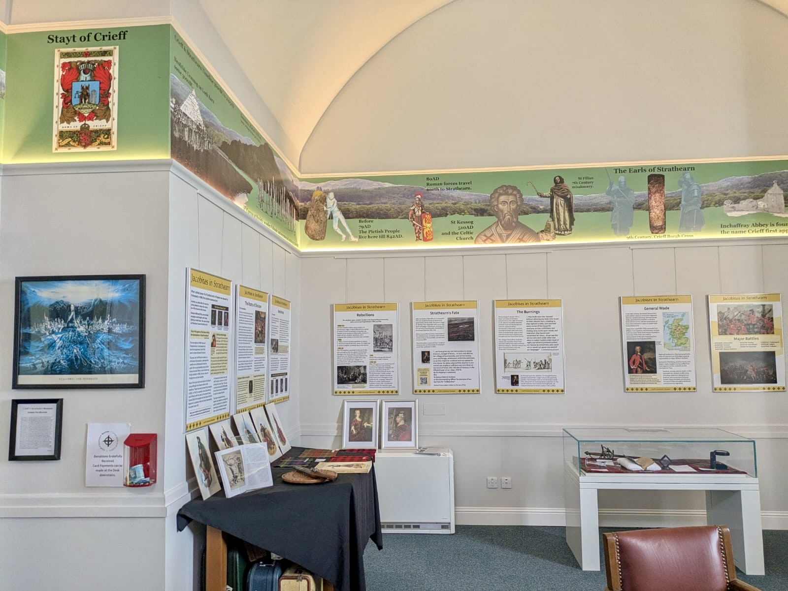Photograph of the upper floor of Crieff and Strathearn Museum, where a graphic timeline of the area wraps around the walls, with further interpretation display boards below.